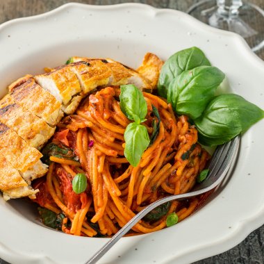 Hähnchenbrust Piccata Milanese serviert mit einfachen One Pot Spaghetti und einem Glas Rotwein