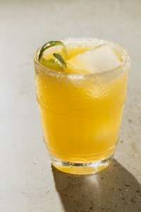Kalorienarmer Cocktail mit Tequila, Orangen- und Limettensaft, serviert mit einer Limettenschale