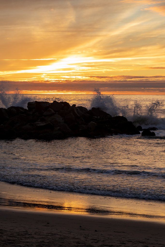 Sonnenuntergang am Meer mit peitschenden Wellen.