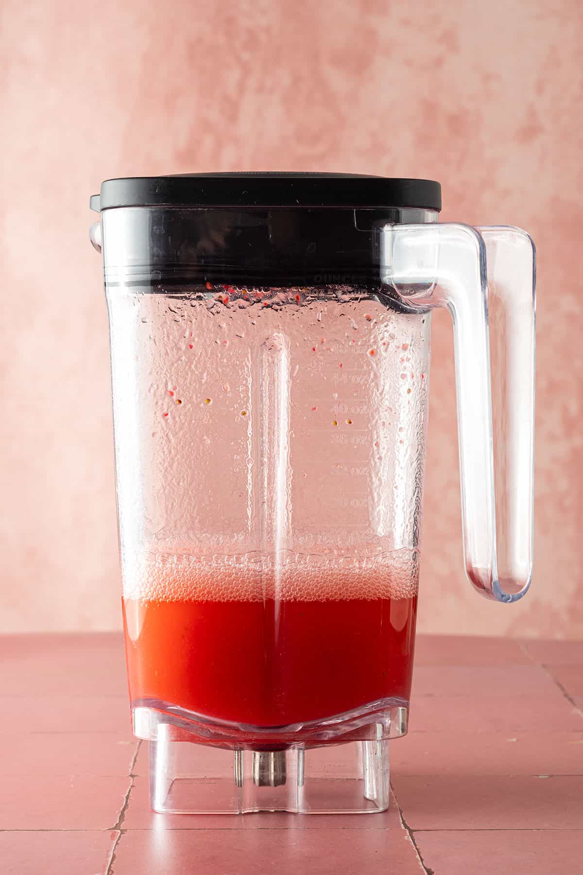 Gemixert, dünnflüssiger, rote Drink in einem Mixbehälter.