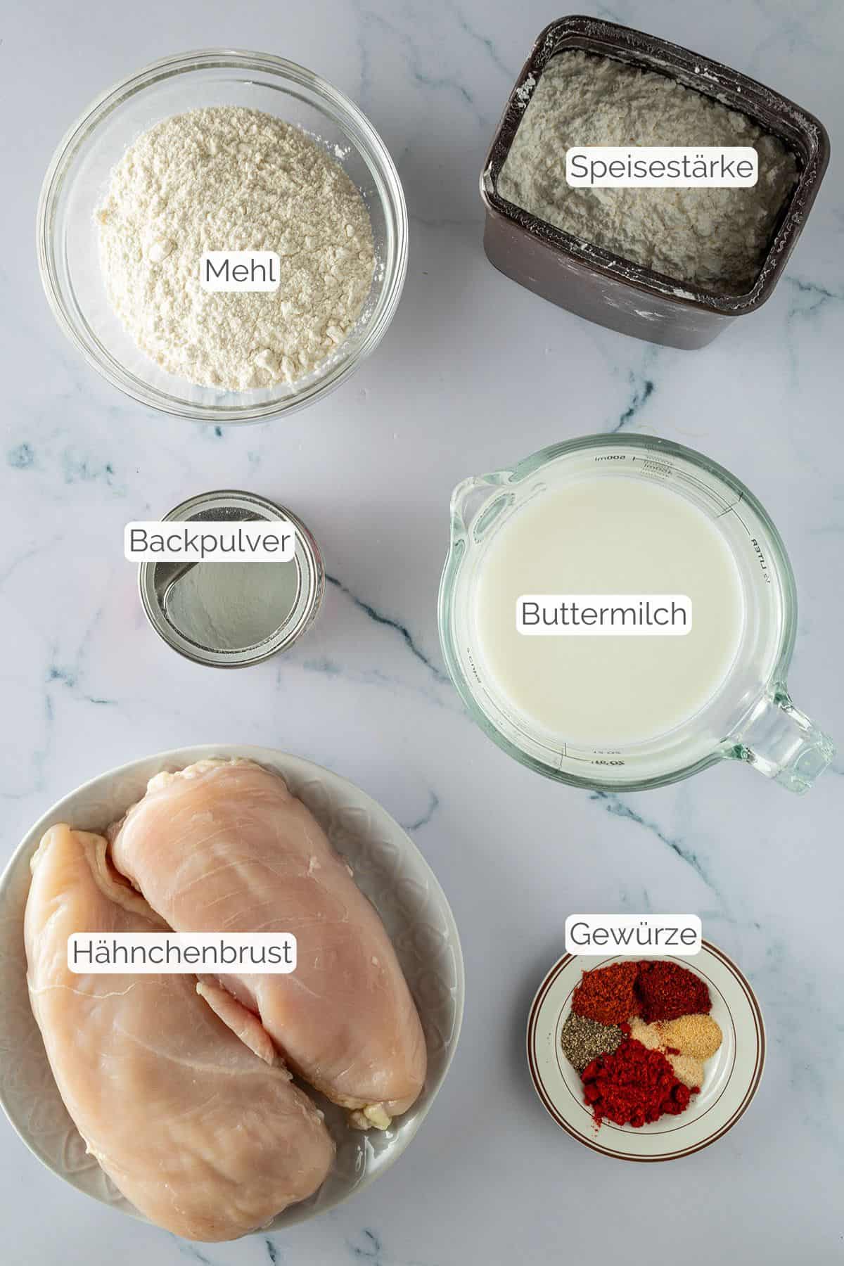 Alle Zutaten mit jeweiligen Textbeschriftungen, die für Fried Chicken aus dem Airfryer benötigt werden.