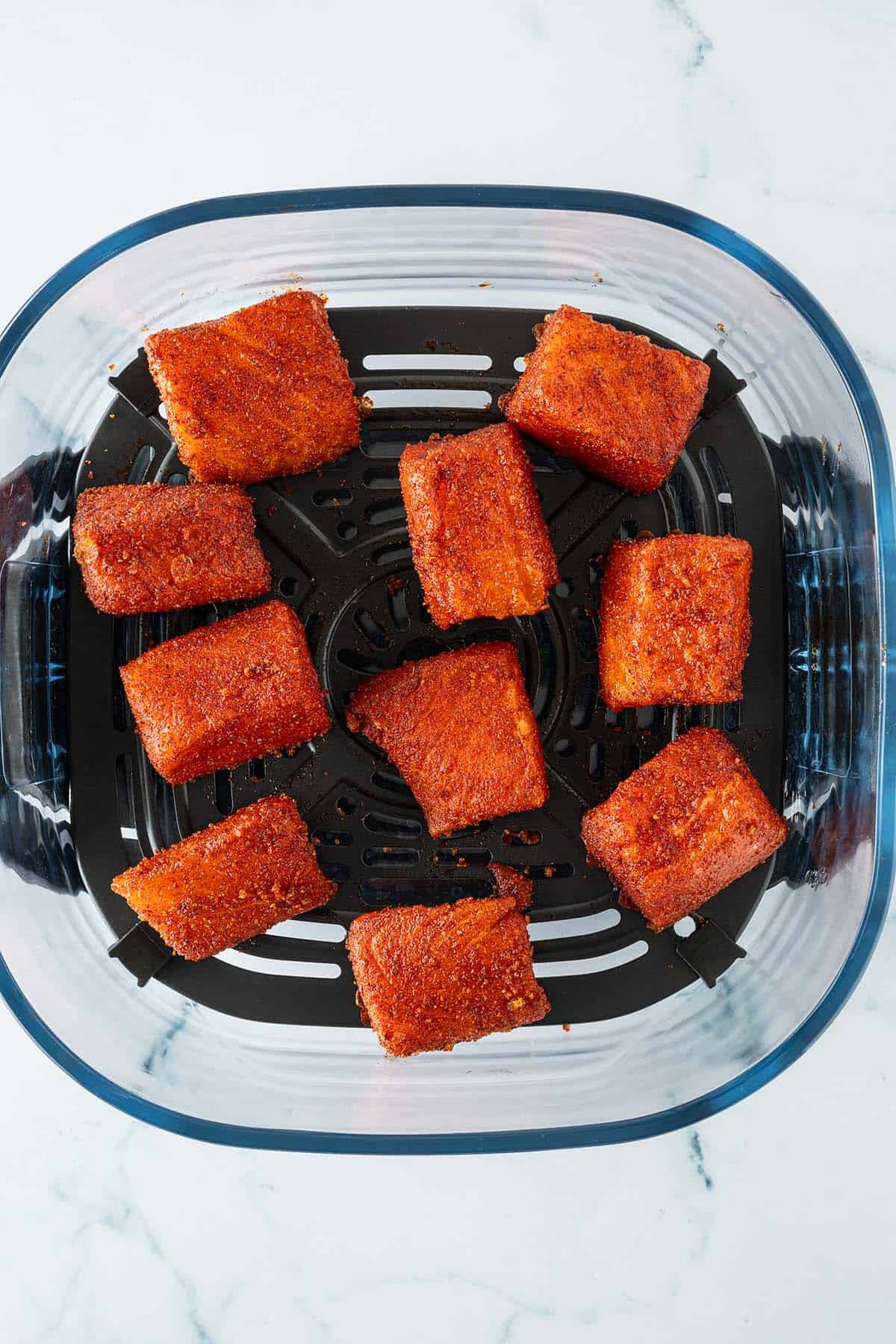 Marinierte Lachsw&uuml;rfel in einem Airfryer.