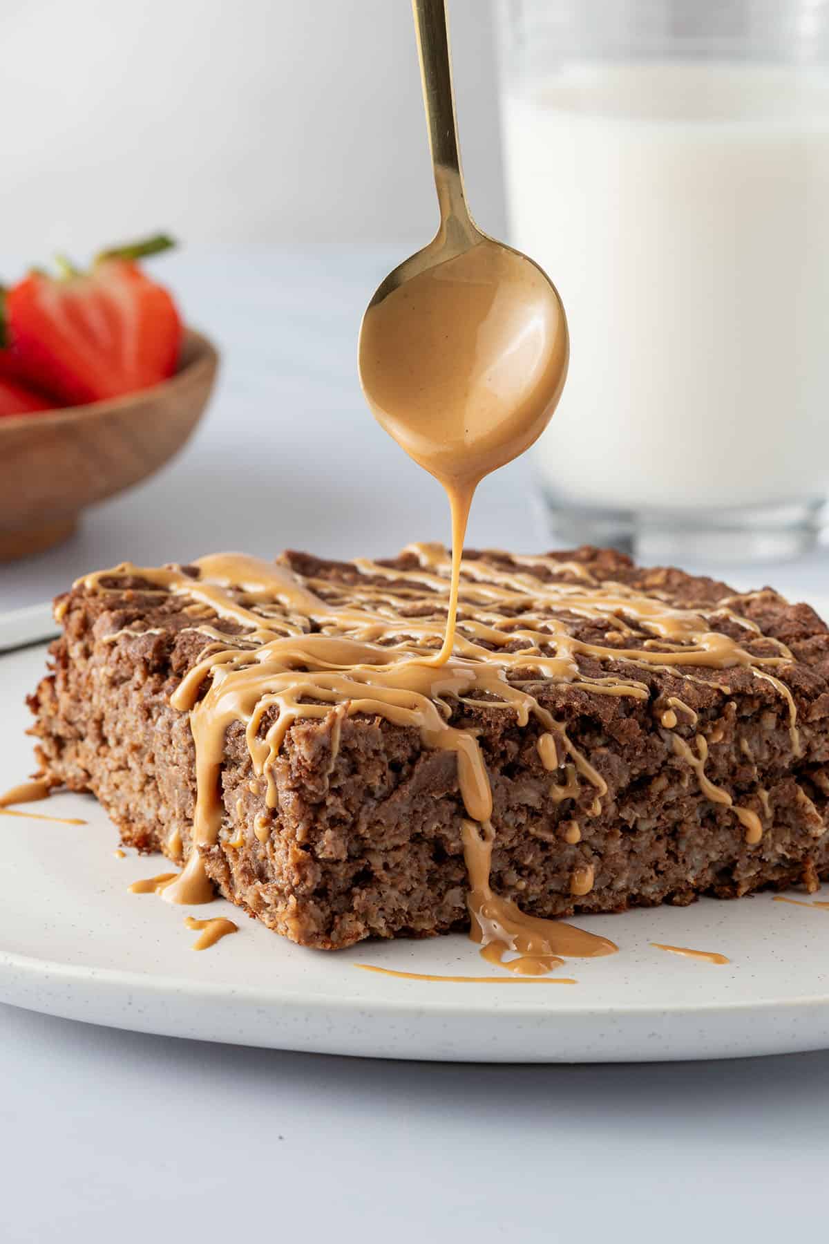 Eine Portion des Baked Oatmeals wird mit Nussmus beträufelt.