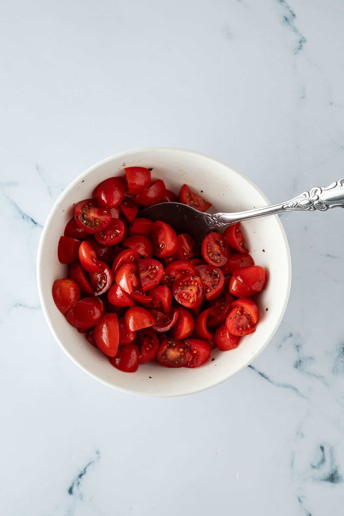 Marinierte Cherrytomaten in einer Schüssel mit Salz und Pfeffer.