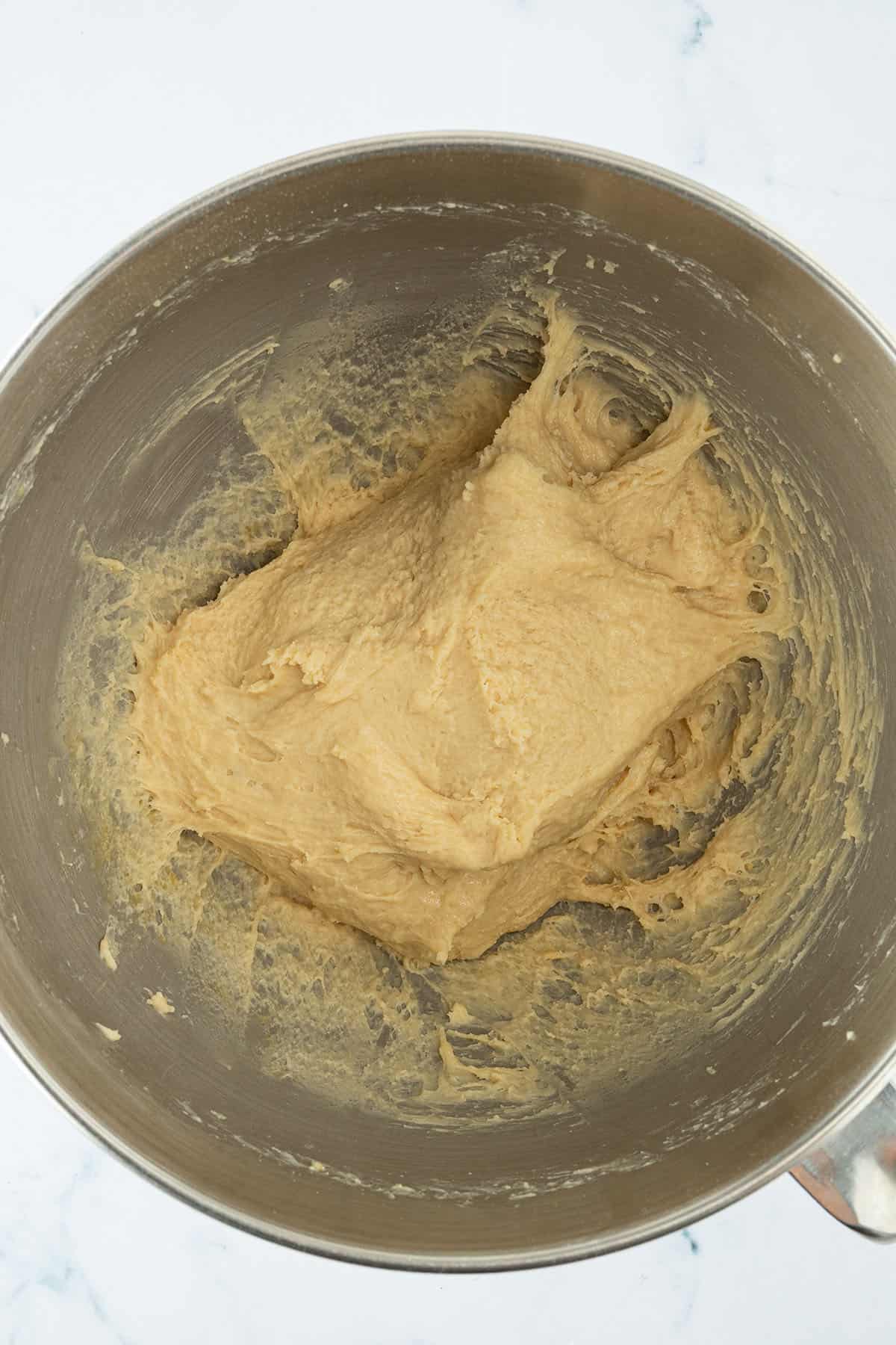 Weicher Brioche-Teig nach dem Kneten in der R&uuml;hrsch&uuml;ssel mit glatter, elastischer Oberfl&auml;che.