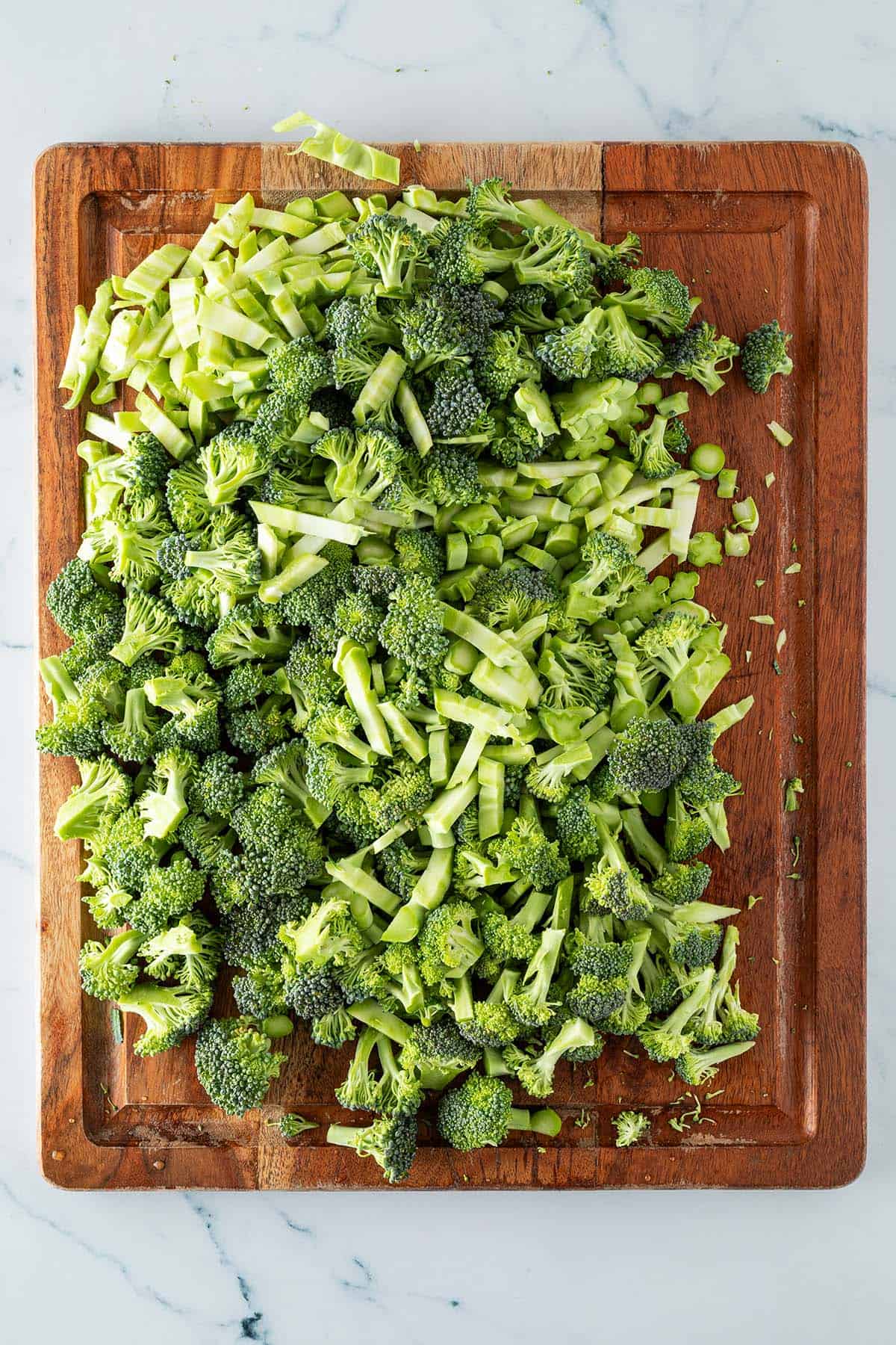 Fein geschnittener Brokkoli auf einem Holzbrett.