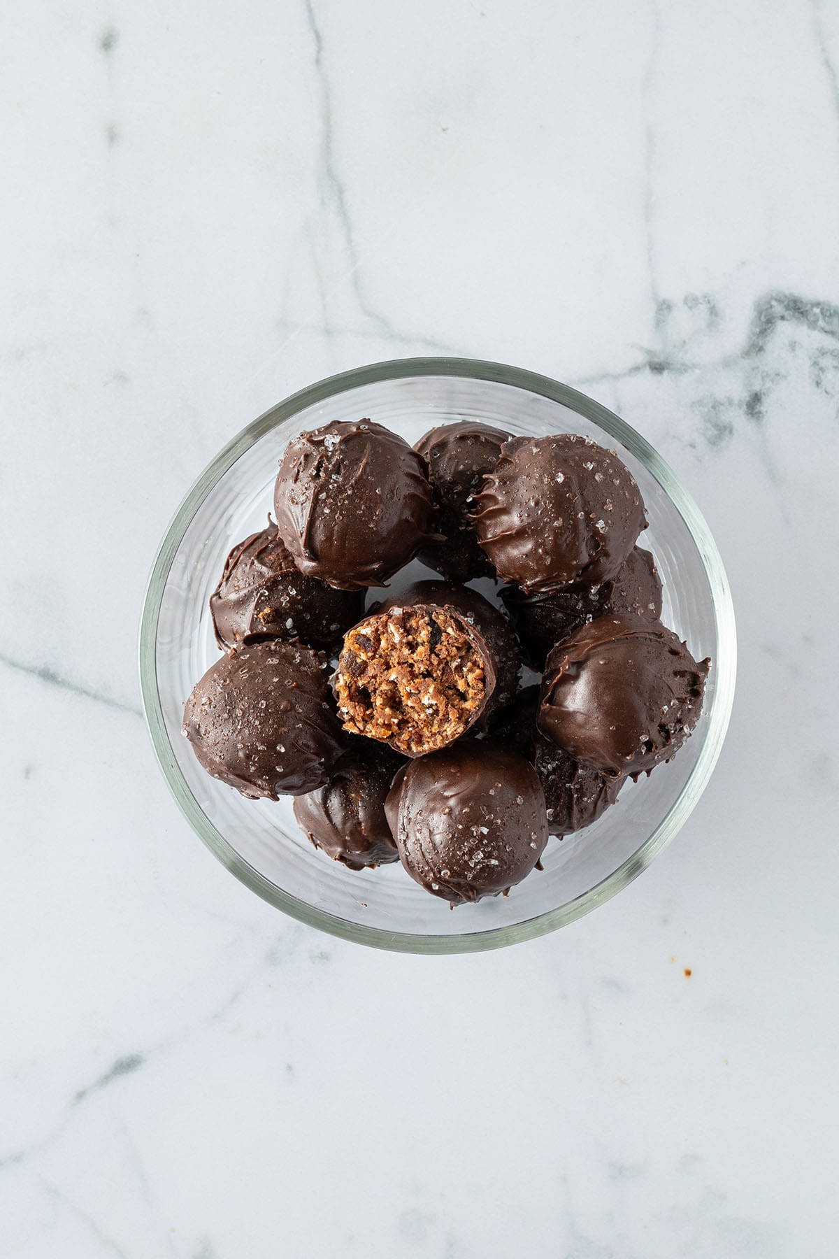 Mit Schokolade überzogene Energy Balls in einer Glas Schüssel.