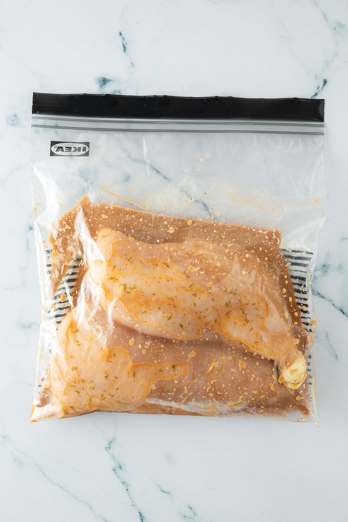 Marinierte Hähnchenbrustfilets in wiederverschließbarem Beutel mit Limetten-Marinade.