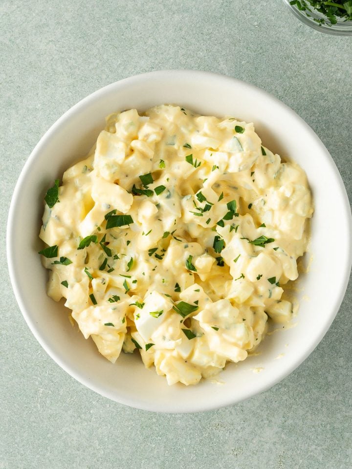 Eiersalat ohne Mayo in einer Schüssel mit Petersilie.