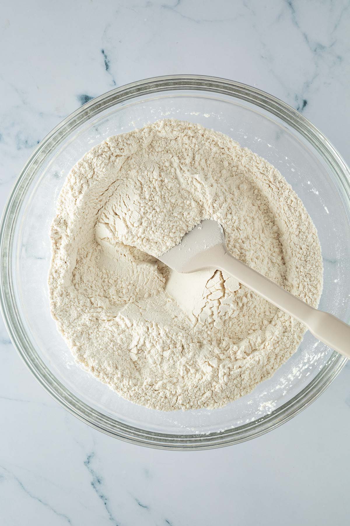 Mehl, Salz und Trockenhefe werden für den Focaccia Teig in einer großen Glasschüssel verrührt.