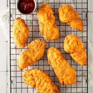 Knuspriges Fried Chicken aus dem Airfryer mit Ketchup auf einem Gitter.