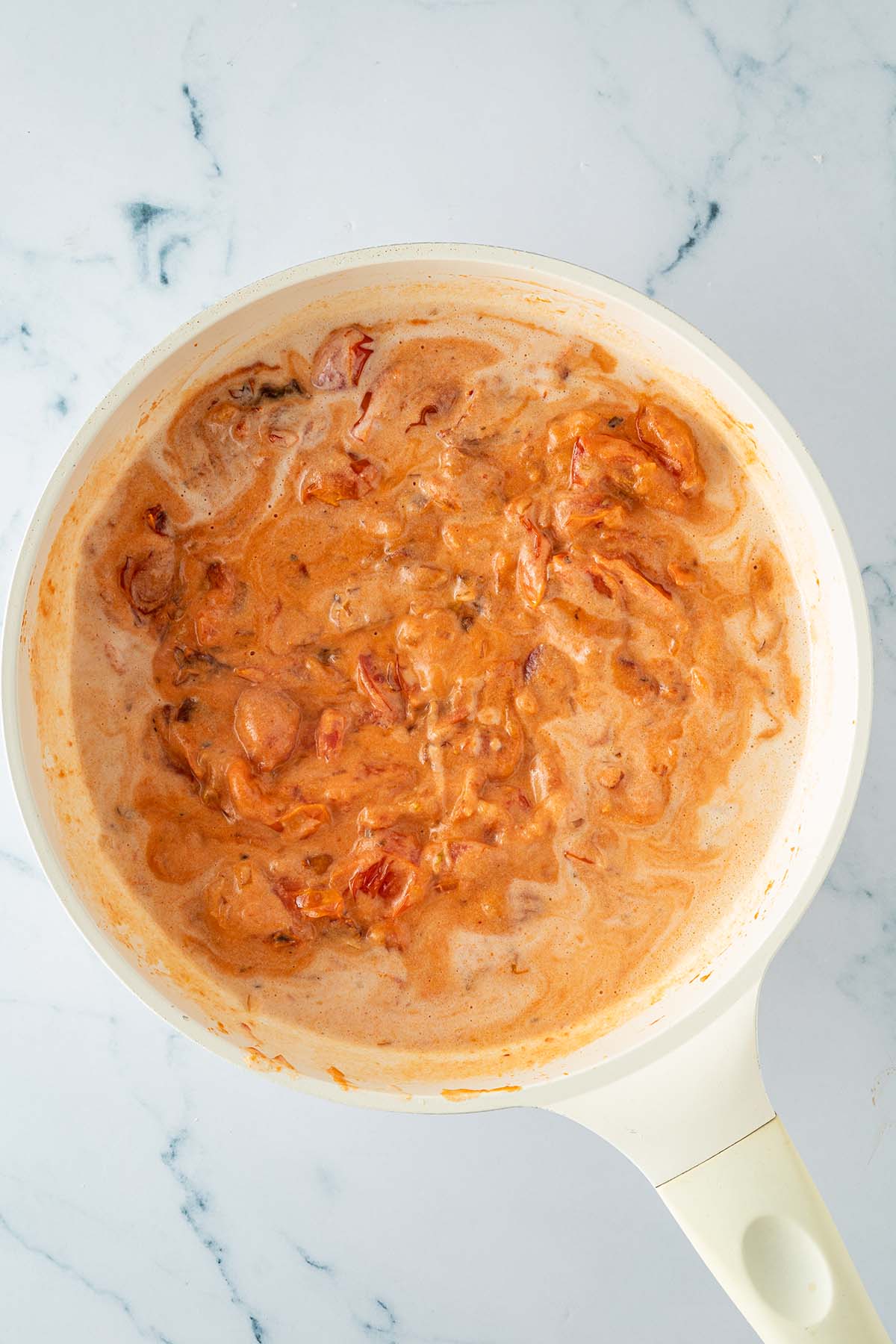 Reduzierte Tomaten-Sahne-Sauce mit getrockneten Tomaten und frischen Tomaten in einer Pfanne, ohne Gnocchi.