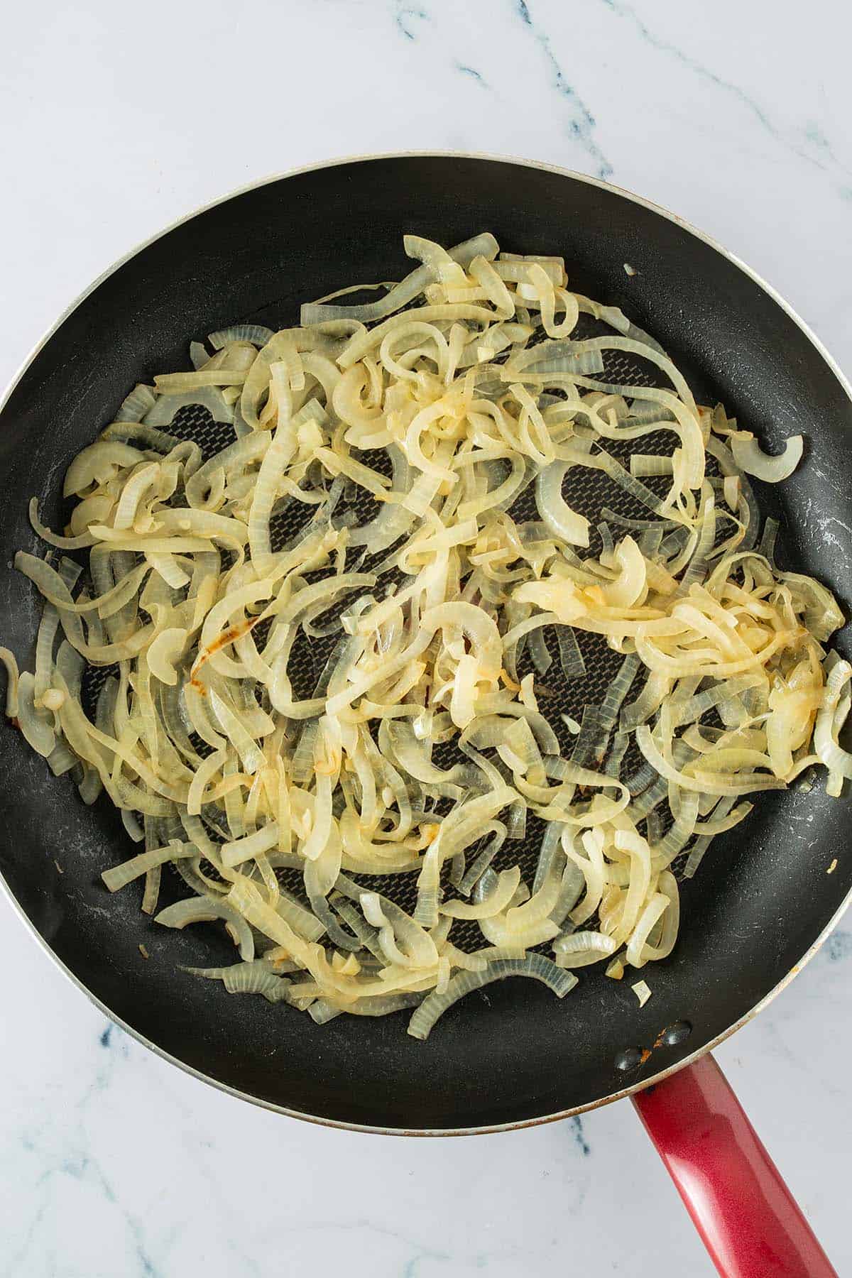 Zwiebeln werden in einer Pfanne weich angebraten.