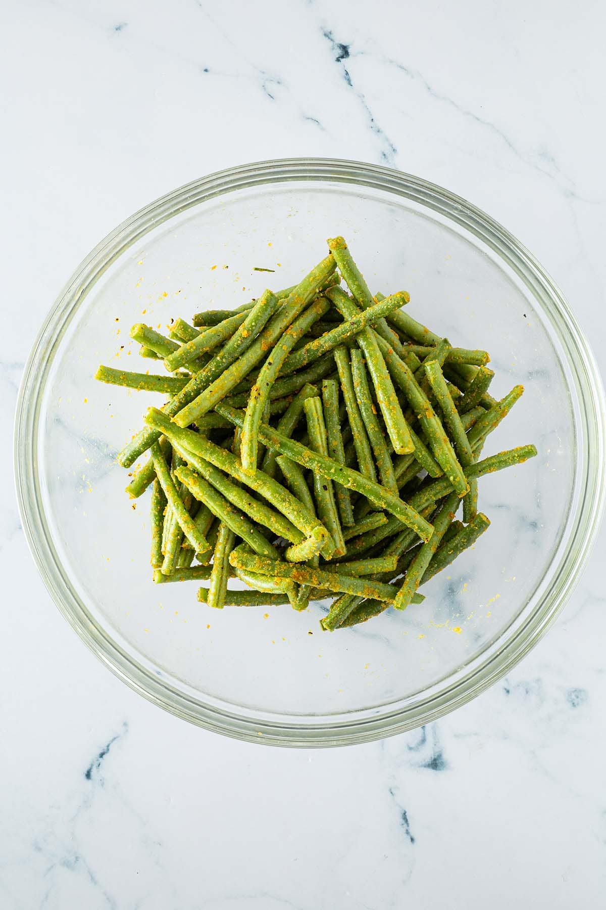 Mit Hefeflocken, Öl und Salz gewürzte Bohnen ein einer großen Glasschüssel.