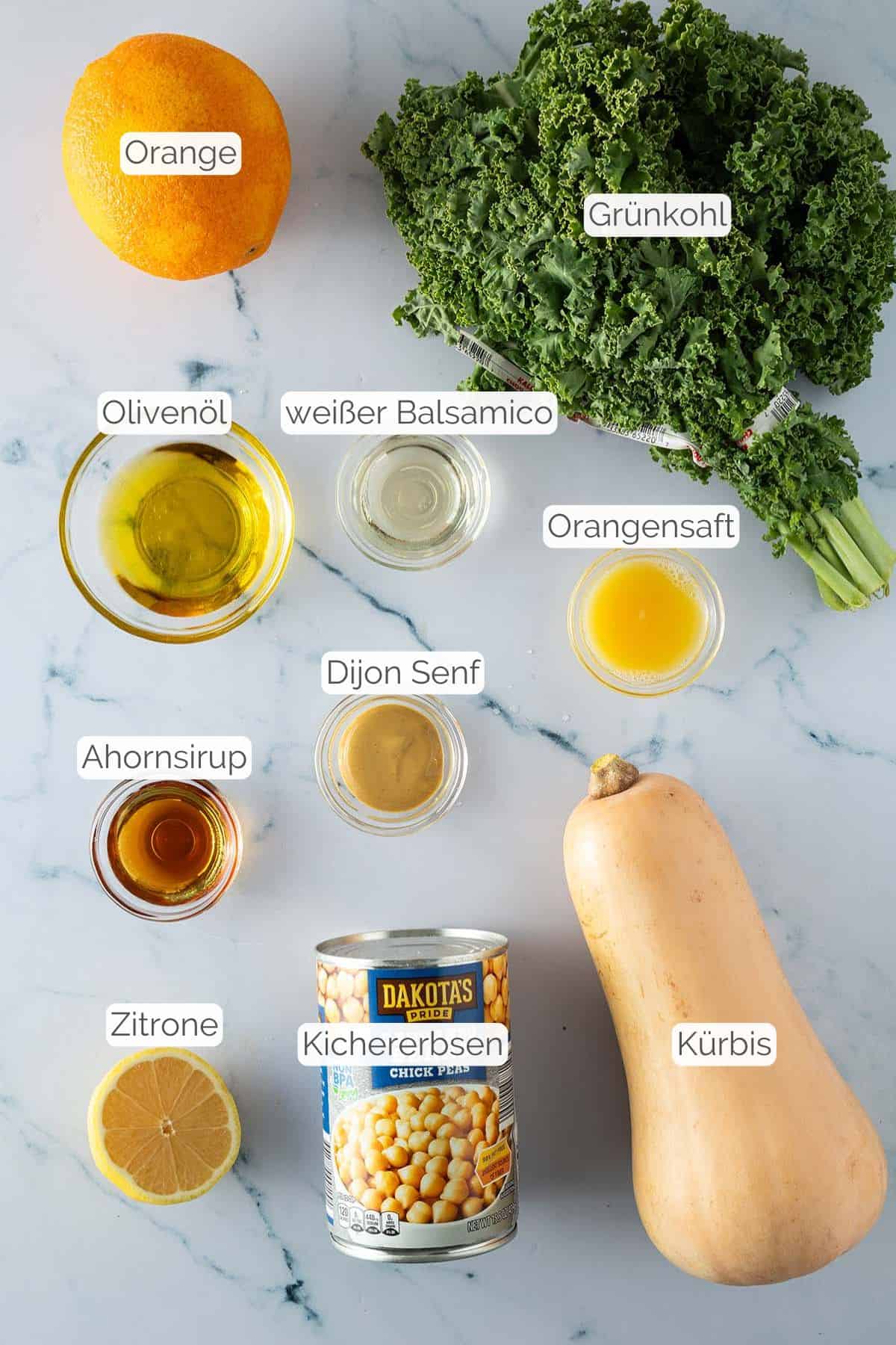 Alle Zutaten, beschriftet, die für den winterlichen Grünkohlsalat mit Orange benötigt werden.