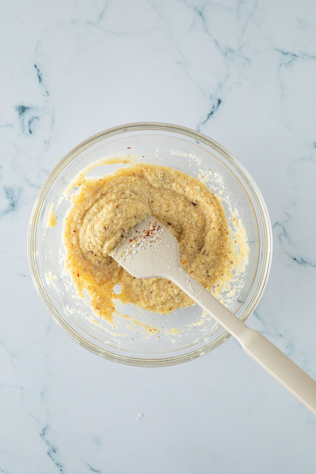 Semmelbr&ouml;sel, Milch, Parmesan, Ei und Gew&uuml;rze werden in einer Sch&uuml;ssel verr&uuml;hrt.