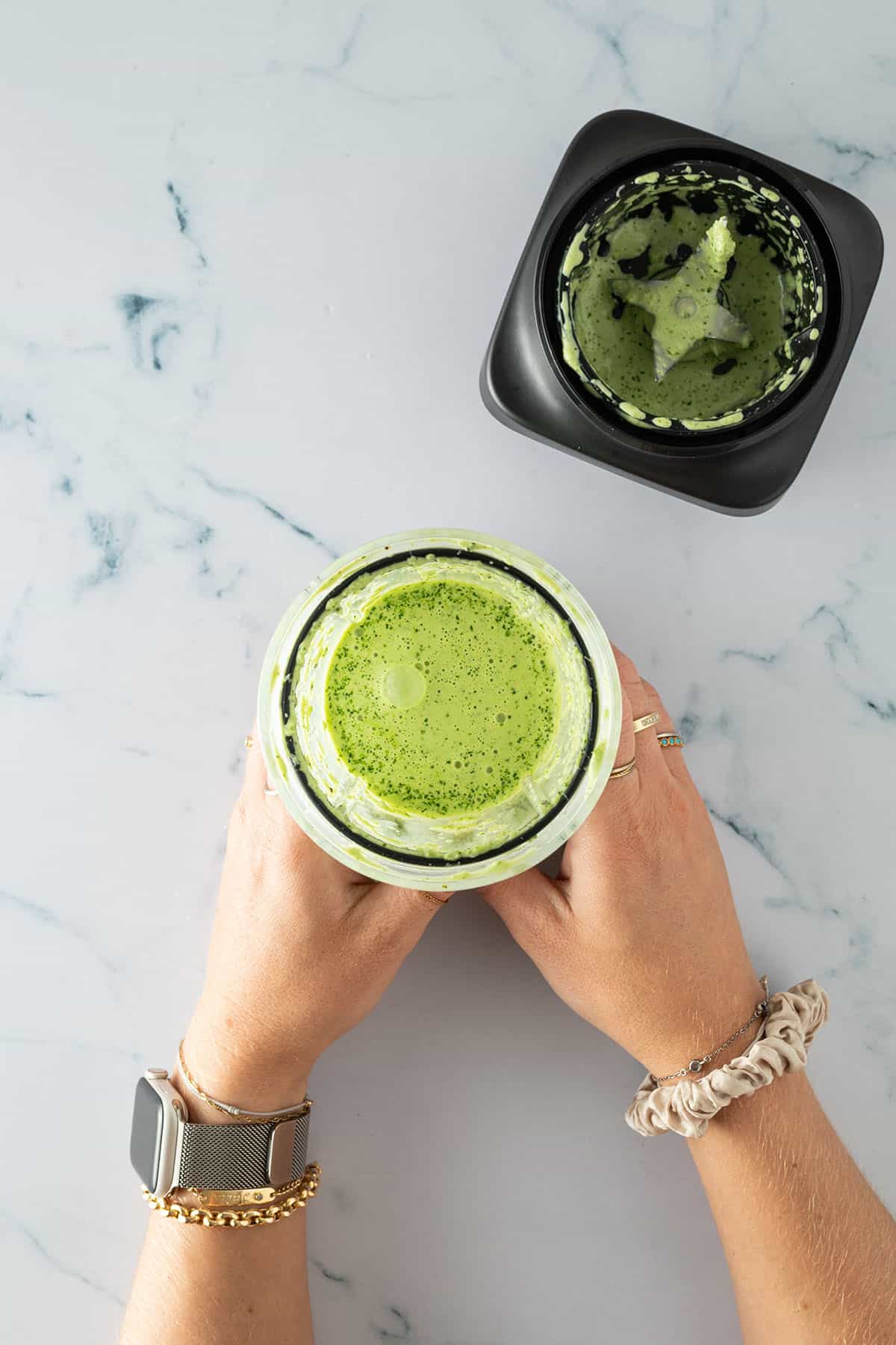 Mixerbeh&auml;lter mit gr&uuml;ner, p&uuml;rierter Sauce (Aji Verde), gehalten in zwei H&auml;nden.