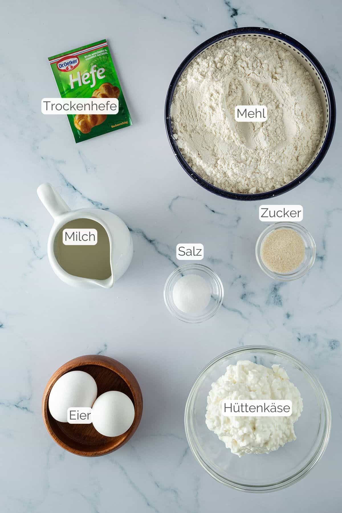 Alle Zutaten mit jeweiligen Textbeschriftungen, die f&uuml;r das H&uuml;ttenk&auml;se Brot ben&ouml;tigt werden.