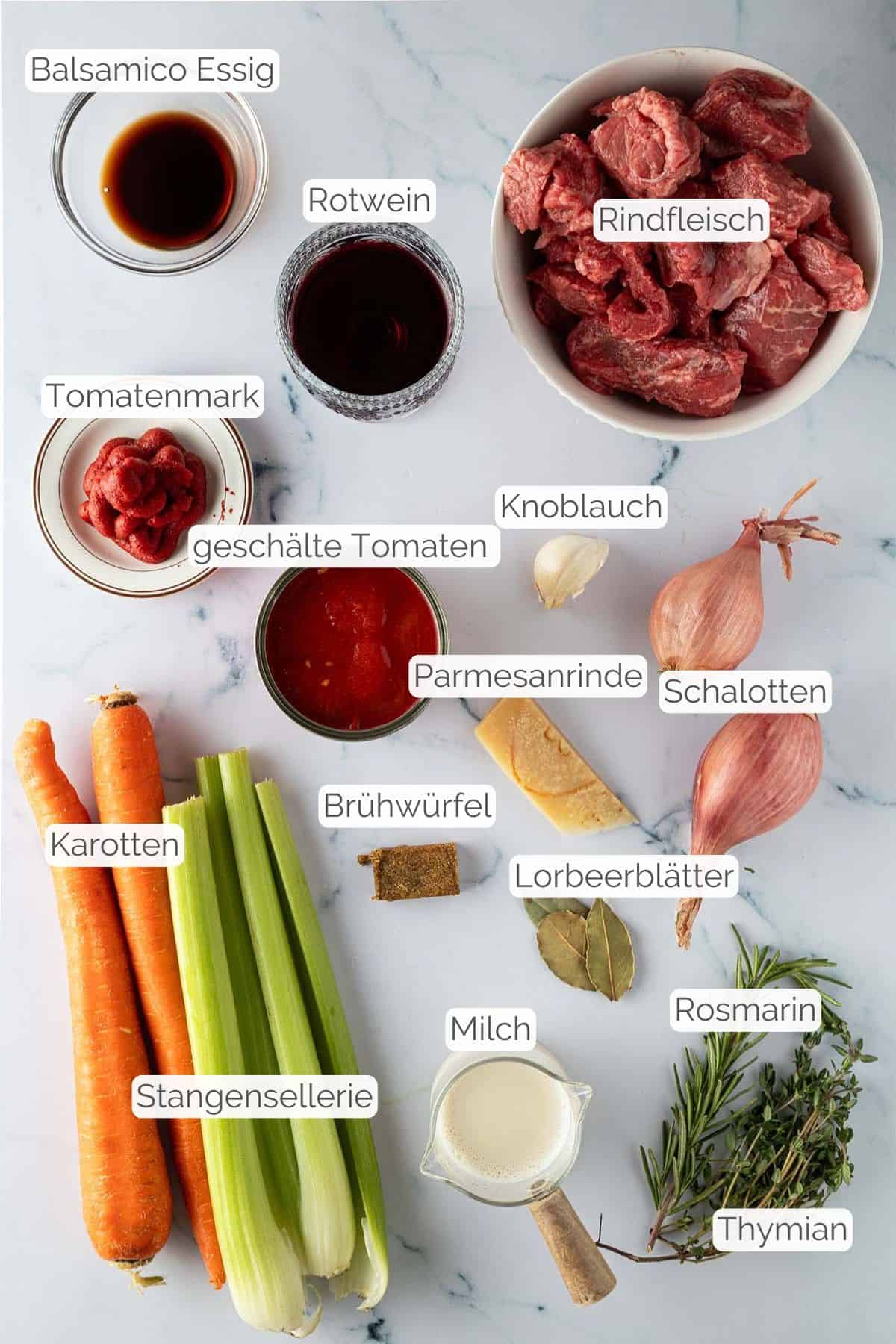 Alle Zutaten mit jeweiligen Textbeschriftungen, die für das italienische Rinderragout benötigt werden.