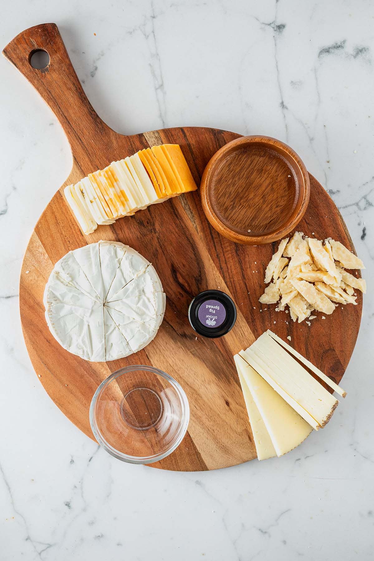 Angeschnittene Käse platziert auf der Käseplatte mit zwei leeren Schüsseln.