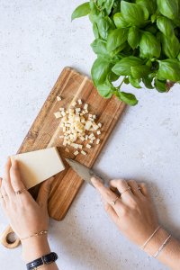 Zubereitungsbild zeigt wie Parmesan in kleine Würfel geschnitten wird.