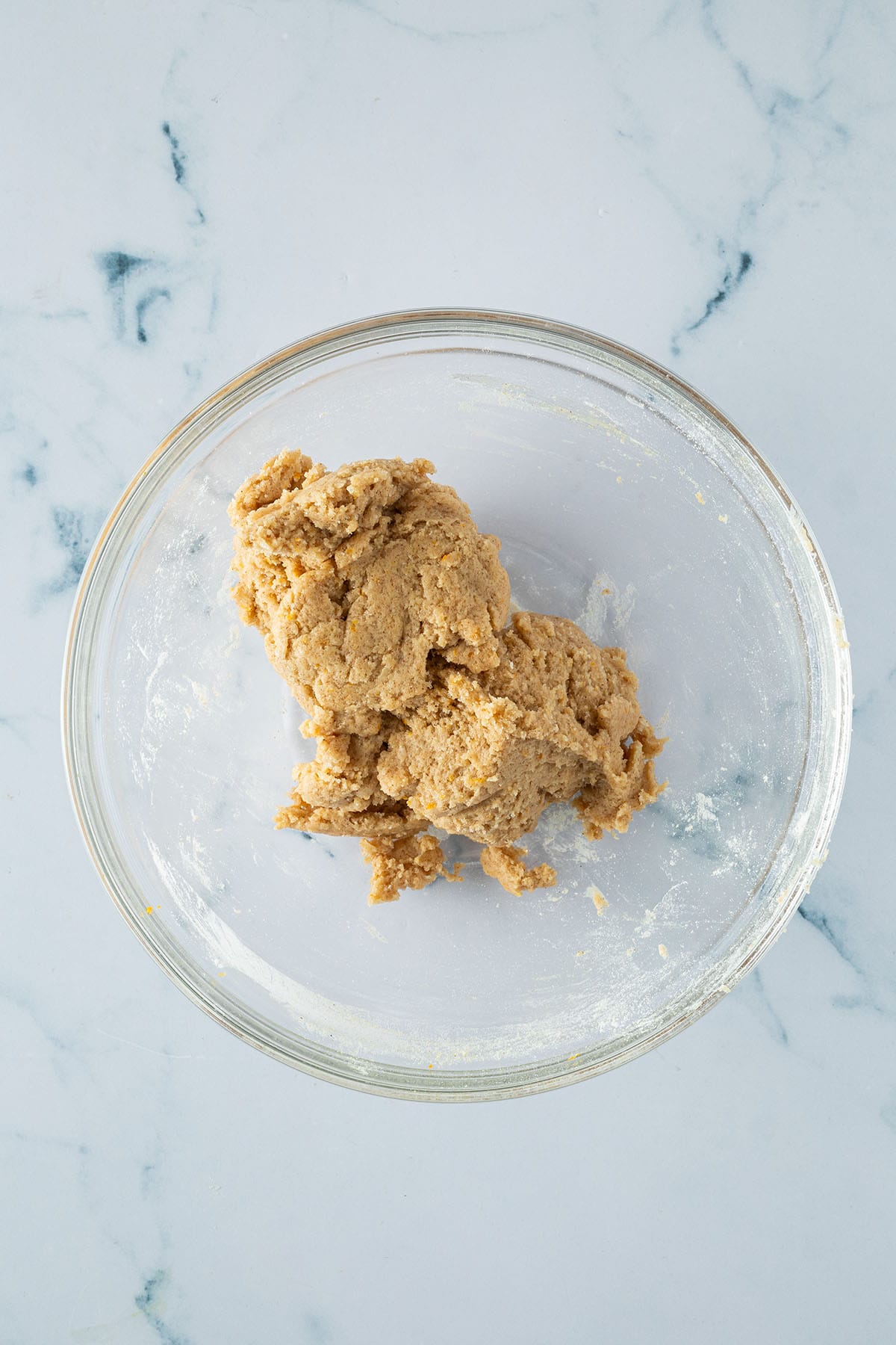 Grundteig für die Kardamom Plätzchen in einer Glasschüssel, bevor Nüsse und Früchte hinzugefügt werden.