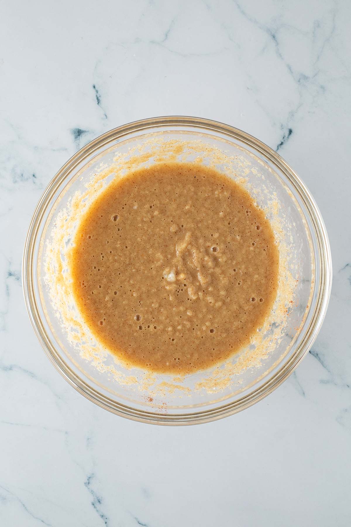 Flüssige Teigbasis für Karotten-Baked-Oats in Glasschüssel verrührt.