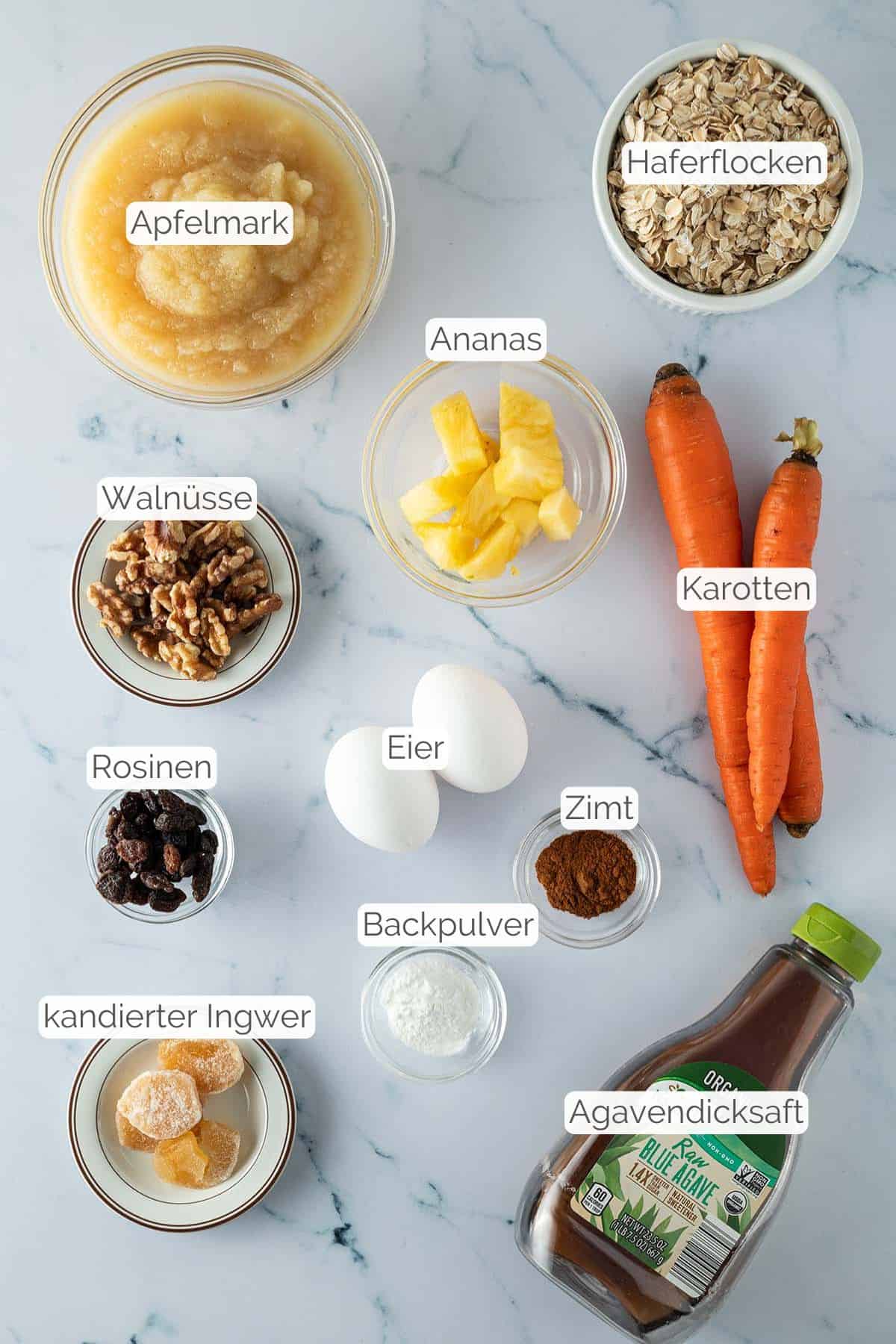Alle Zutaten mit jeweiligen Textbeschriftungen, die für die Karotten Baked Oats benötigt werden.