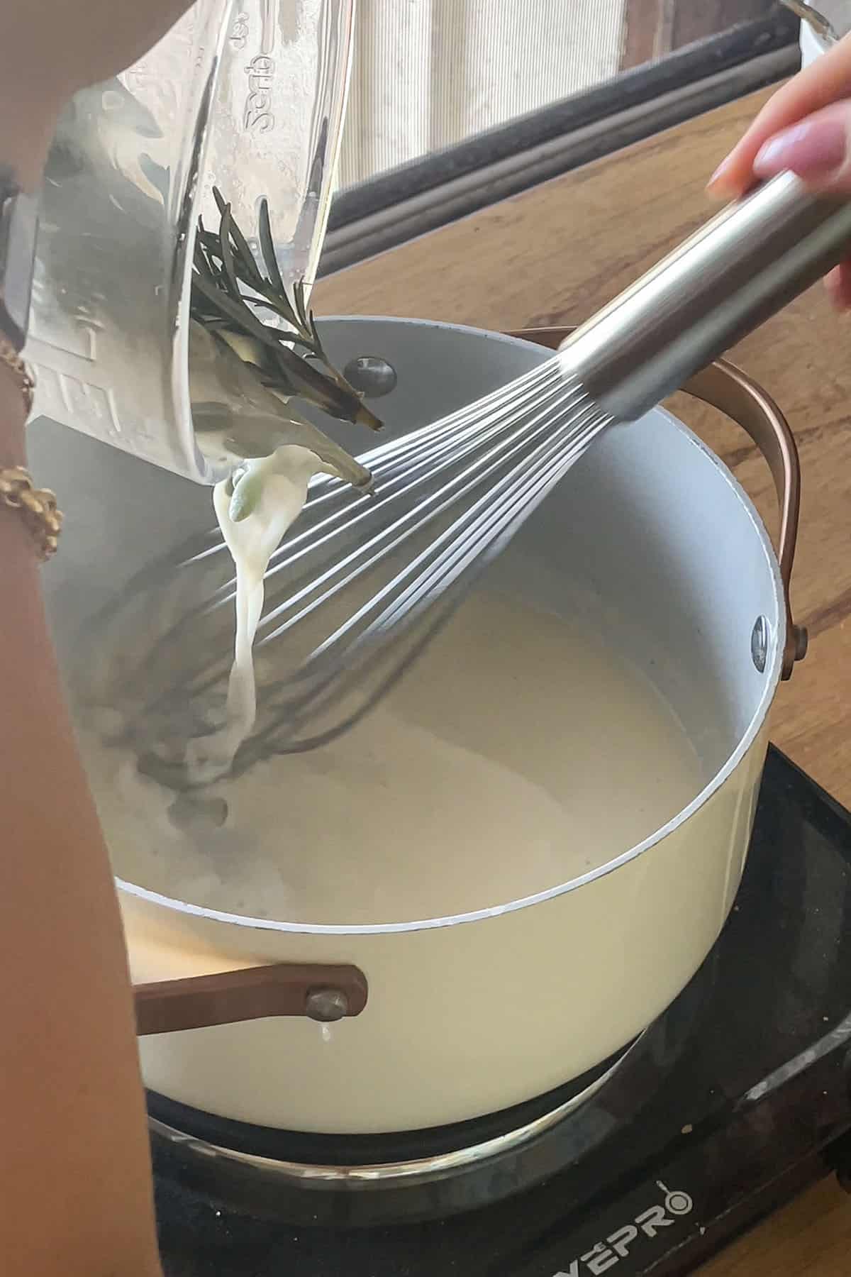 Mehlschwitze wird langsam unter Rühren mit der aromatisierten Milch aufgegossen.