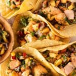 Mehrere Lachs Tacos mit Pfirsich Salsa auf einem Stück Backpapier, von oben fotografiert.