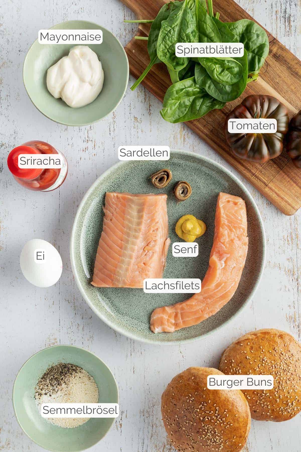 Alle Zutaten mit jeweiligen Textbeschriftungen, die für den Lachsburger mit selbstgemachten Lachs Patty benötigt werden.