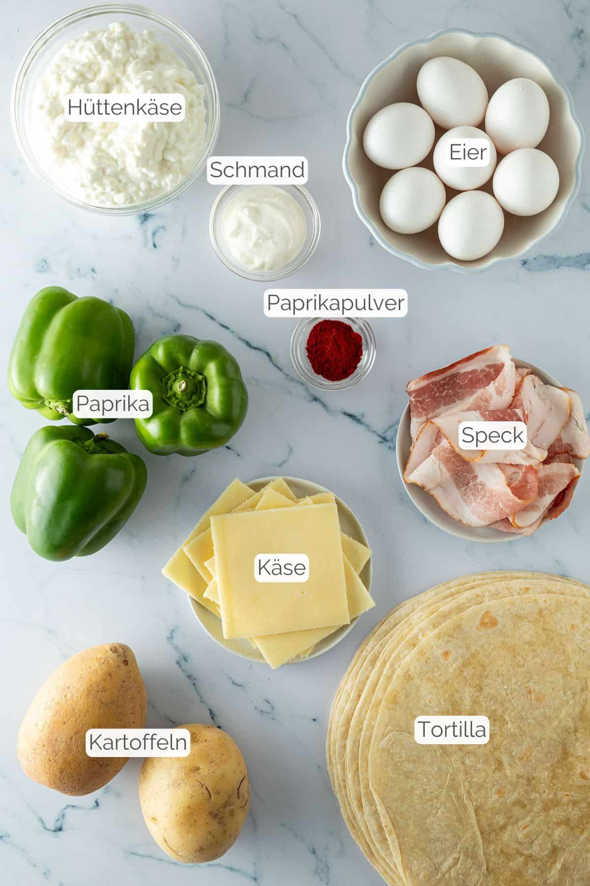 Alle Zutaten mit jeweiligen Textbeschriftungen, die für die herzhaften Meal Prep Frühstück Sandwiches benötigt werden.