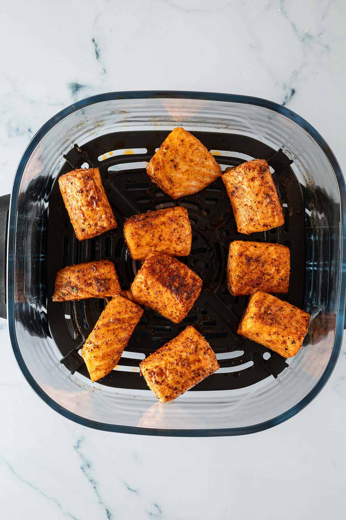 Fertig gegarte Lachswürfel im Airfryer-Korb.