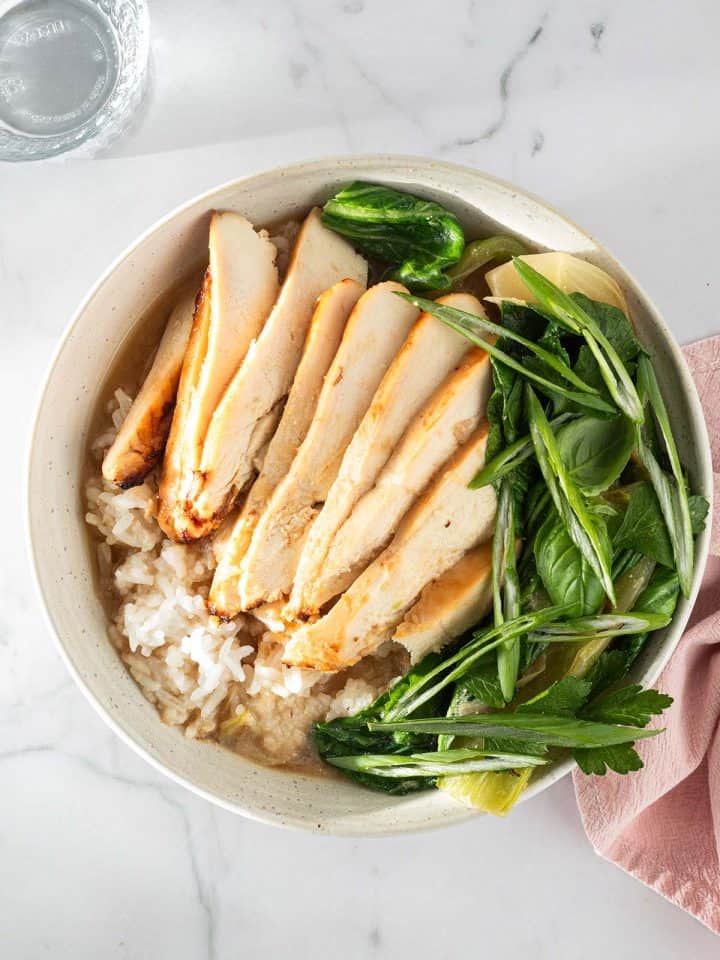 Miso Broth Bowl mit Reis, Hähnchen und Pak Choi in einer hellen Schüssel, serviert mit Frühlingszwiebeln und Kräutern.