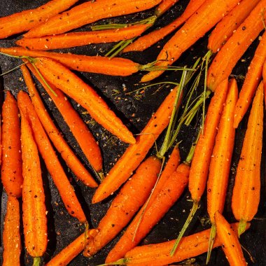 Nahaufnahme von geröstete und karamellisierten Karotten, die auf einem Blech liegen.