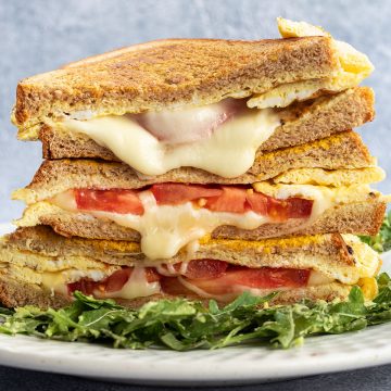Ein Stapel von Sandwiches mit geschmolzenem Käse und Tomaten.