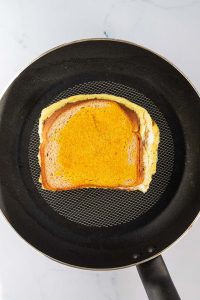 Zusammengeklapptes Omelett Sandwich in einer Pfanne.