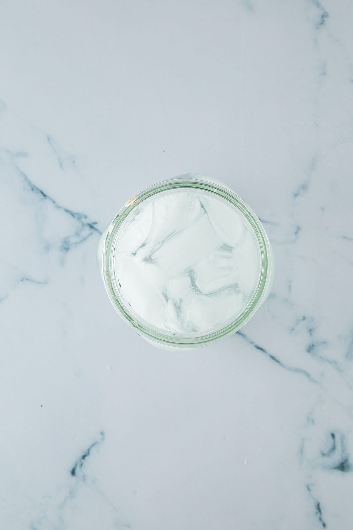 Glas mit Eiswasser f&uuml;r den Pinsa Teig auf heller Arbeitsfl&auml;che.
