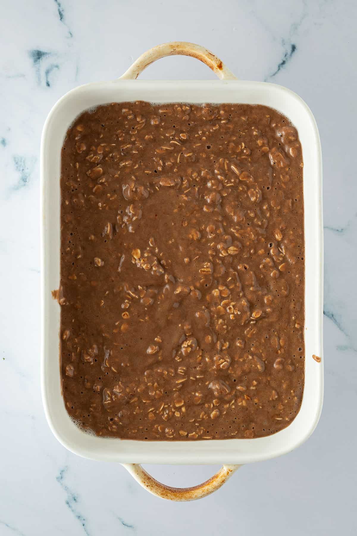 Schokoladen-Haferflocken-Masse f&uuml;r Baked Oatmeal in einer Auflaufform vor dem Backen.