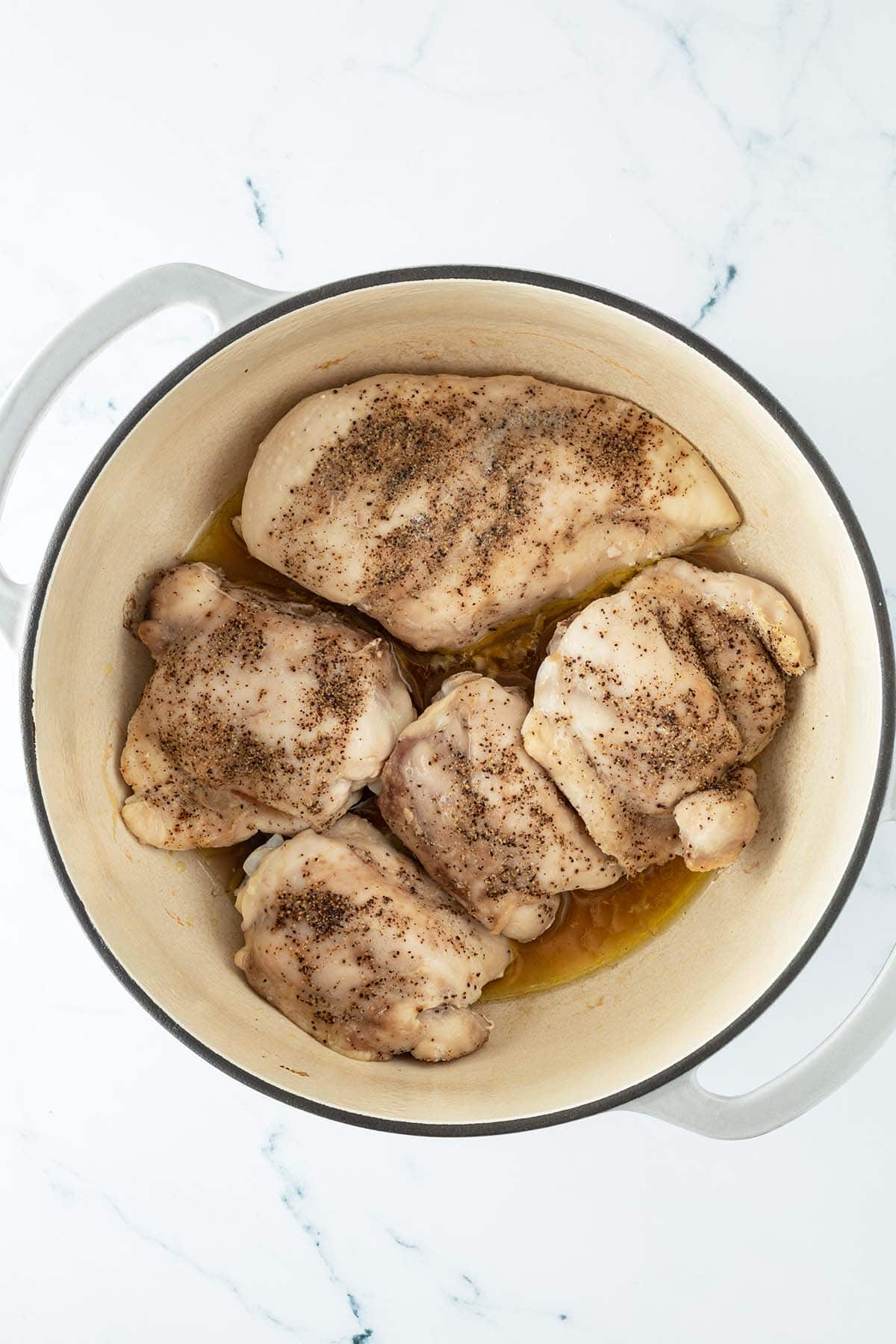 Langsam gegartes H&auml;hnchenfleisch in einem Gusseisentopf.