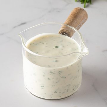 Cremiges selbstgemachtes Ranch Dressing mit frischen Kräutern in einem kleinen Glasgefäß.