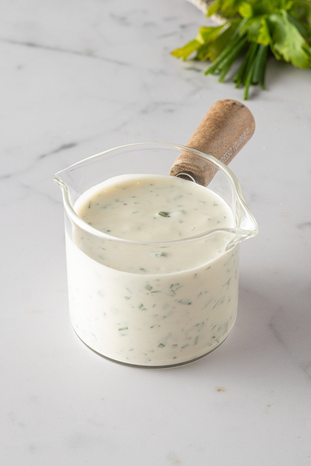 Cremiges selbstgemachtes Ranch Dressing mit frischen Kräutern in einem kleinen Glasgefäß.