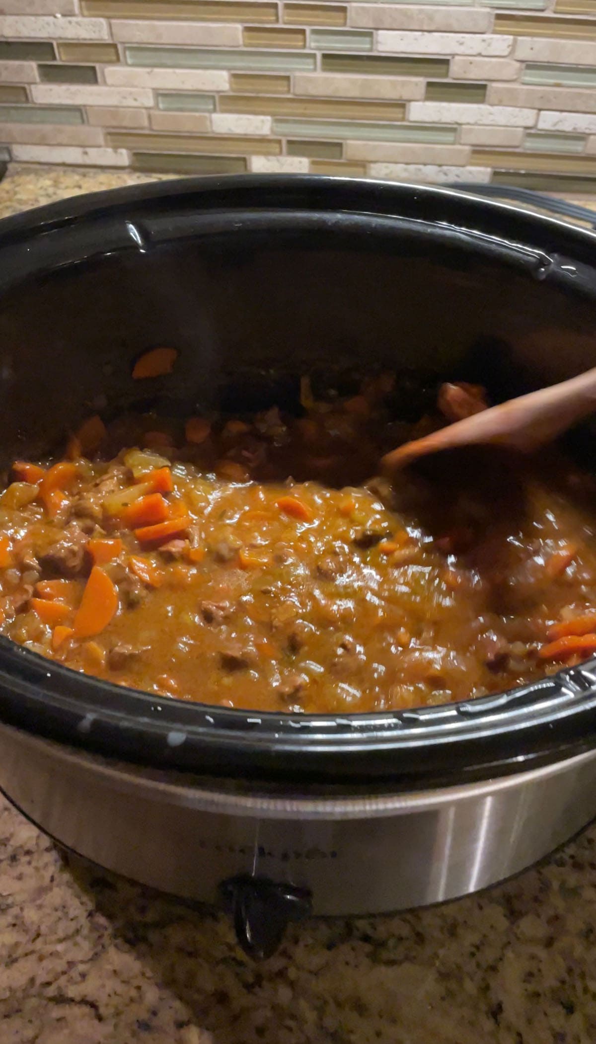 Rindfleischeintopf in einem Slowcooker auf einer K&uuml;chenarbeitsfl&auml;che.