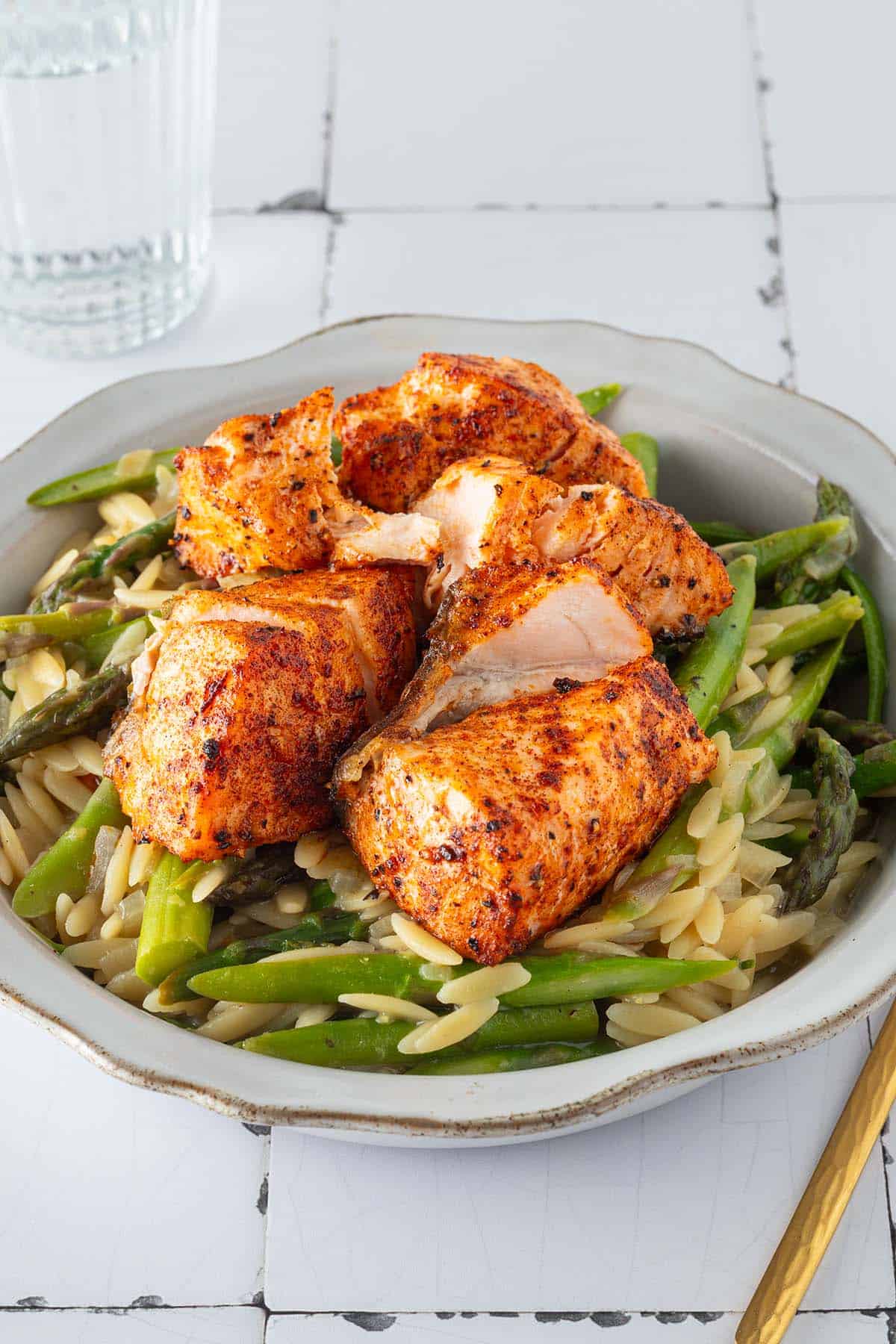 Ein Teller Spargel Lachs Pasta bestehend aus Orzo Nudeln und Spargel in einer cremigen Parmesansauce, getoppt mit Lachsw&uuml;rfeln.