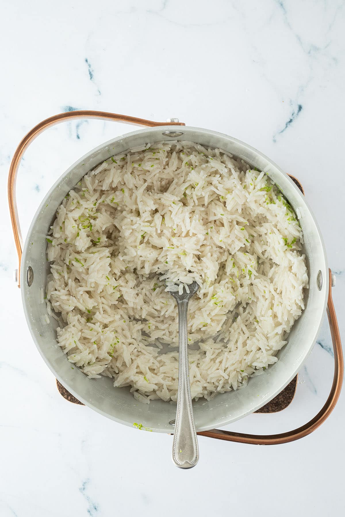 Aufgelockerter Kokosreis mit Limettenabrieb im Topf.
