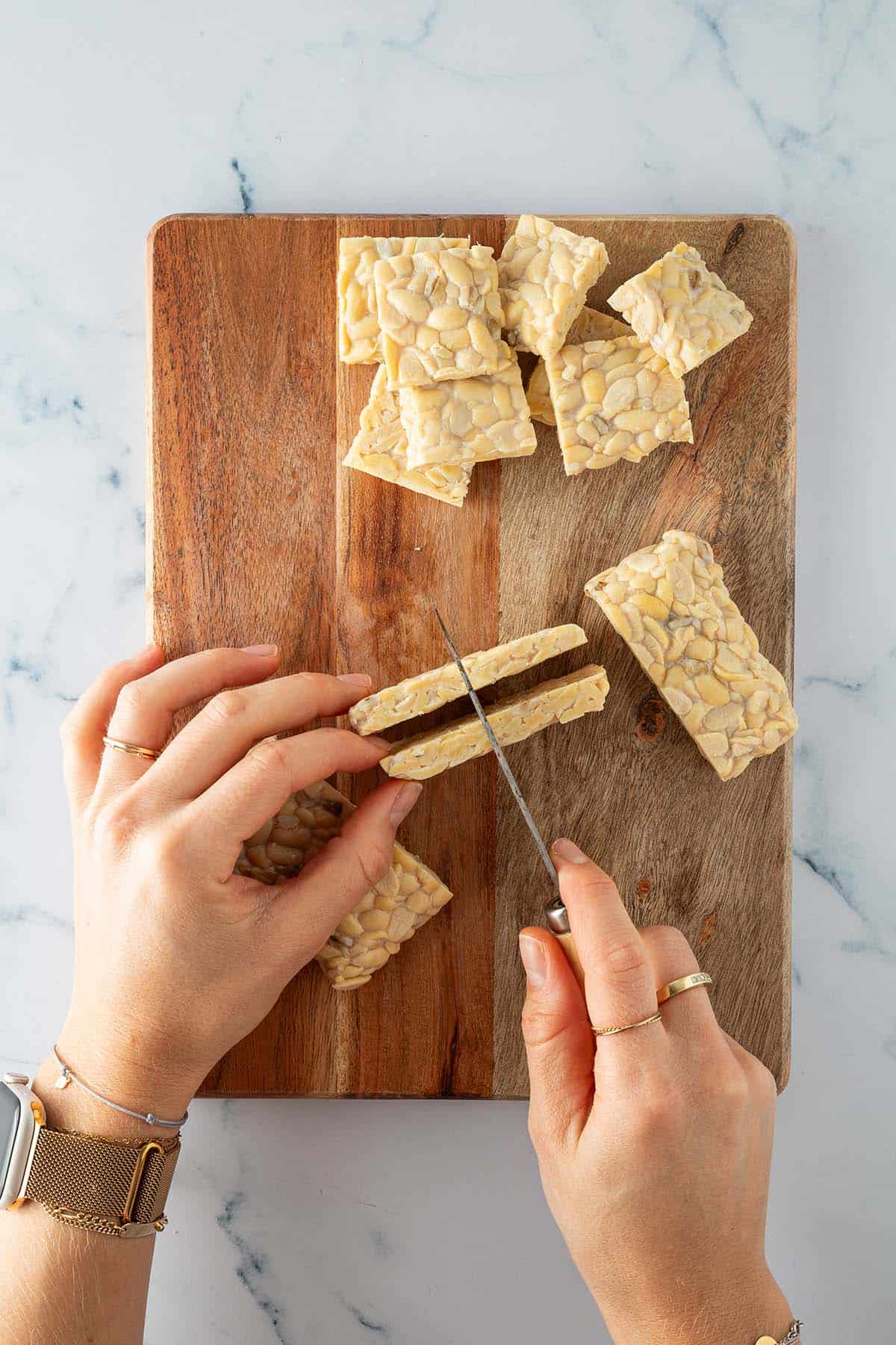 Tempeh wird in flache Rechtecke geschnitten.