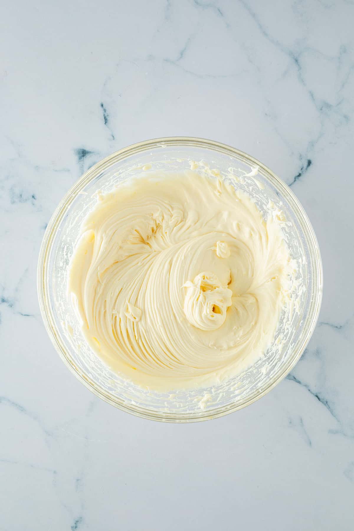 Cremig aufgeschlagene Mascarponecreme in einer Glasschüssel von oben.