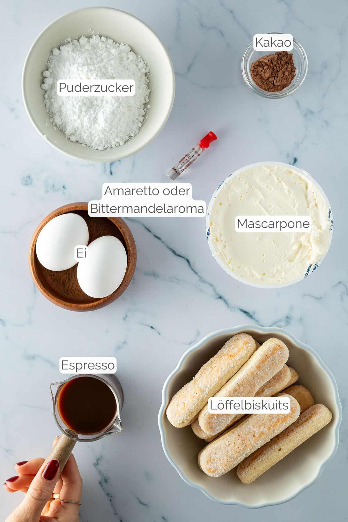 Alle Zutaten, beschriftet, die für Tiramisu im Glas benötigt werden.