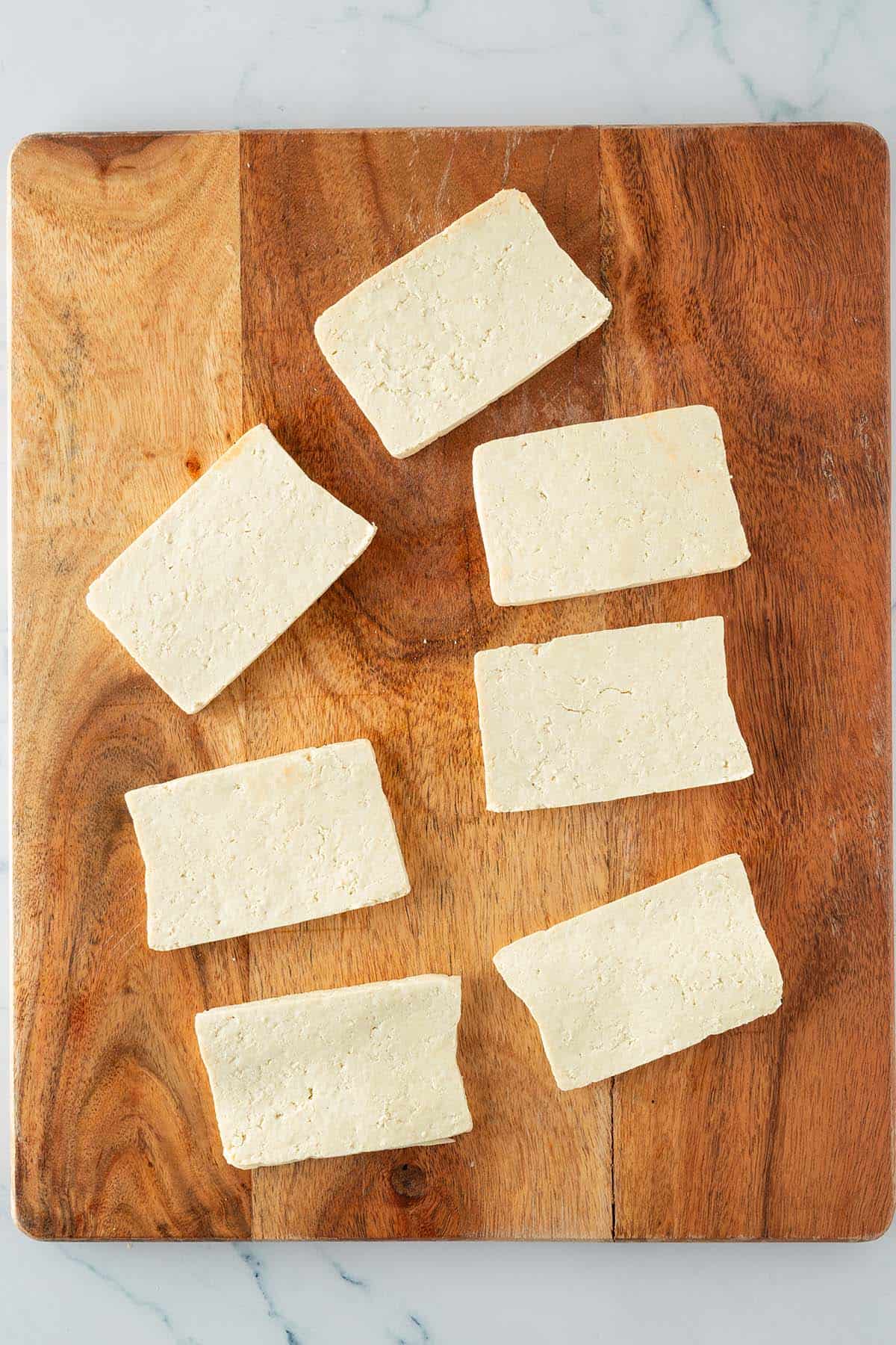 Tofu Scheiben auf einem Holzbrett.