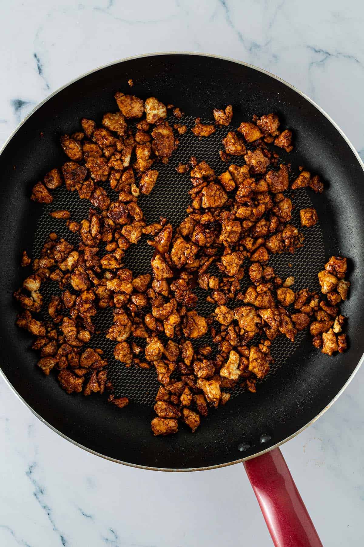 Knusprig gebratener Tofu mit Sojasauce in einer Pfanne.